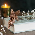 Product photo with one bronze fairy sitting on a mint-coloured book